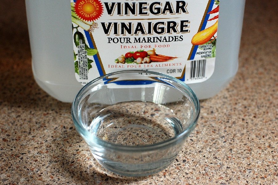Create a mixture using water, laundry detergent, and vinegar
