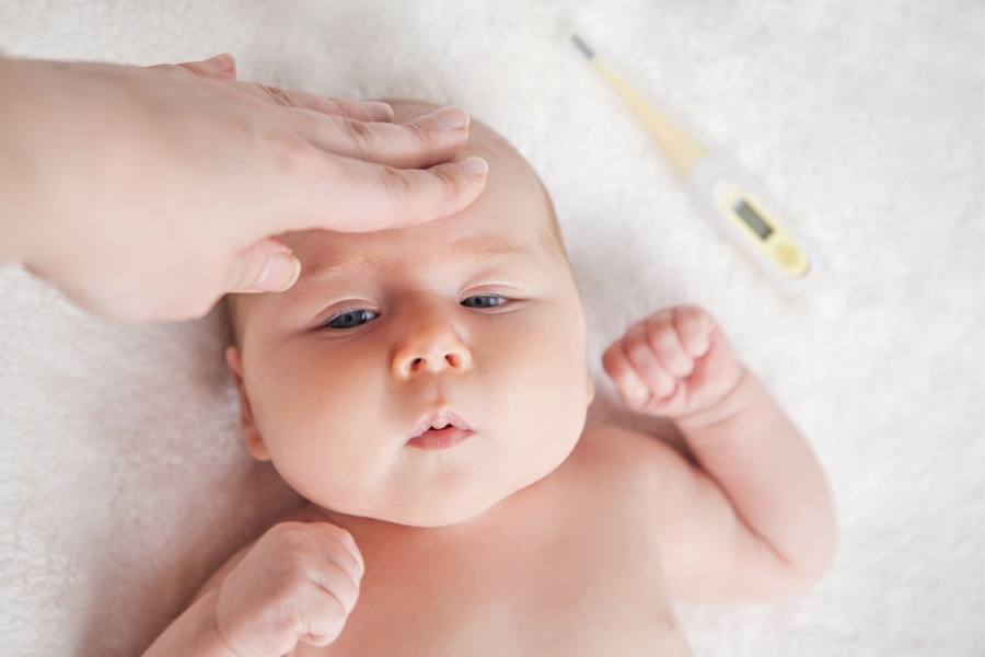 Should you let sick toddler sleep all day -Mom is checking the temperature of her child