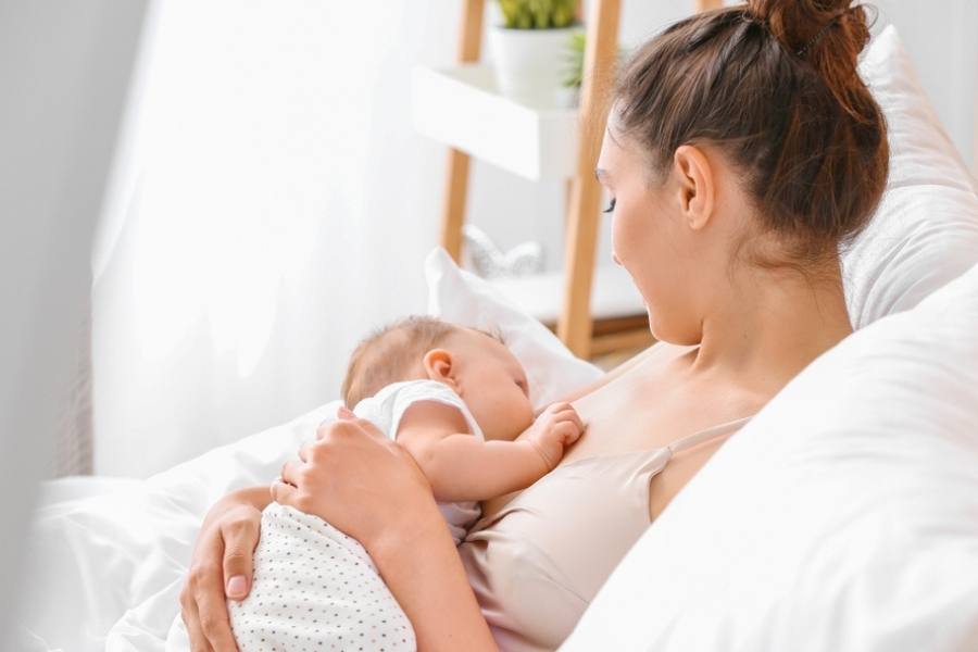 Should you let sick toddler sleep all day -Young woman breastfeeding her child at home 